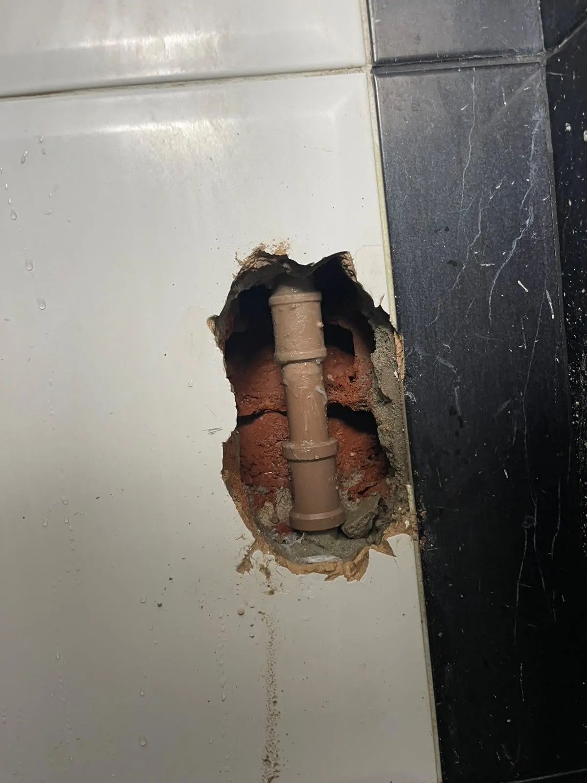 Trecho de cano trocado dentro da parede durante conserto de vazamento